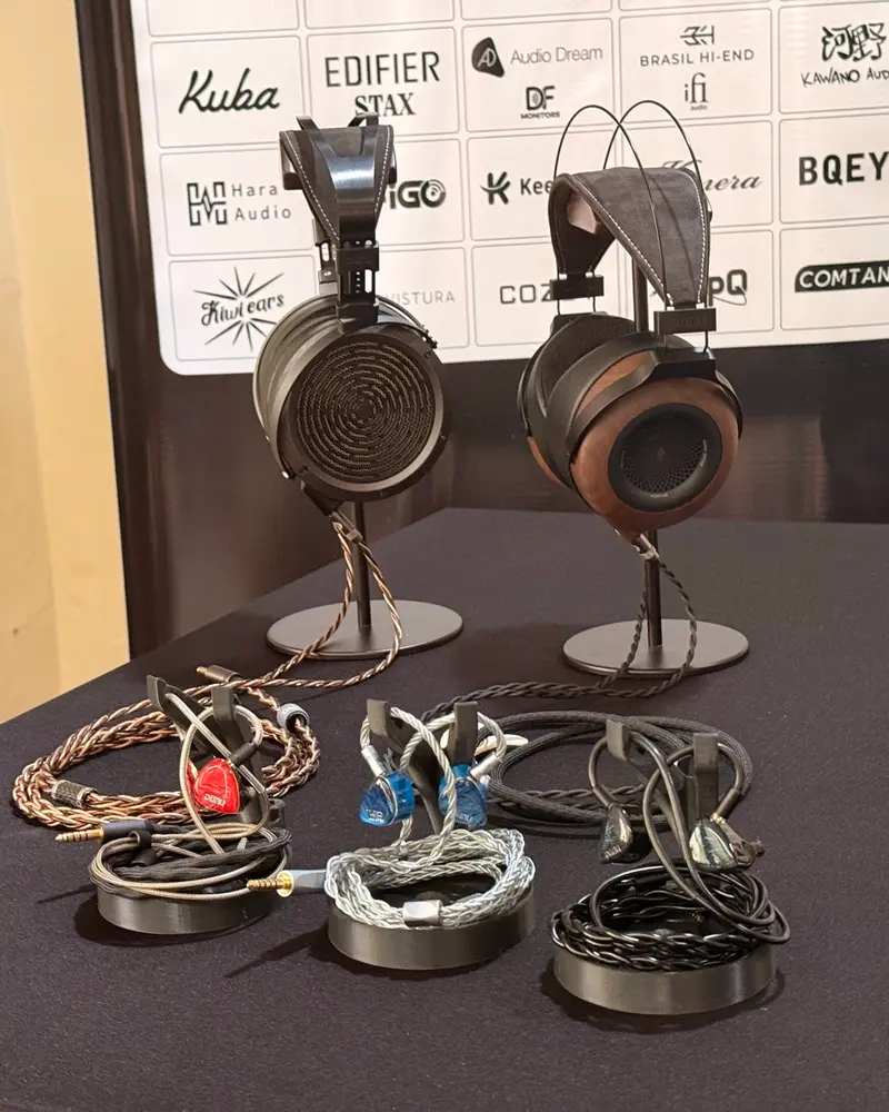 Mesa com fones e plaquinhas das marcas participantes